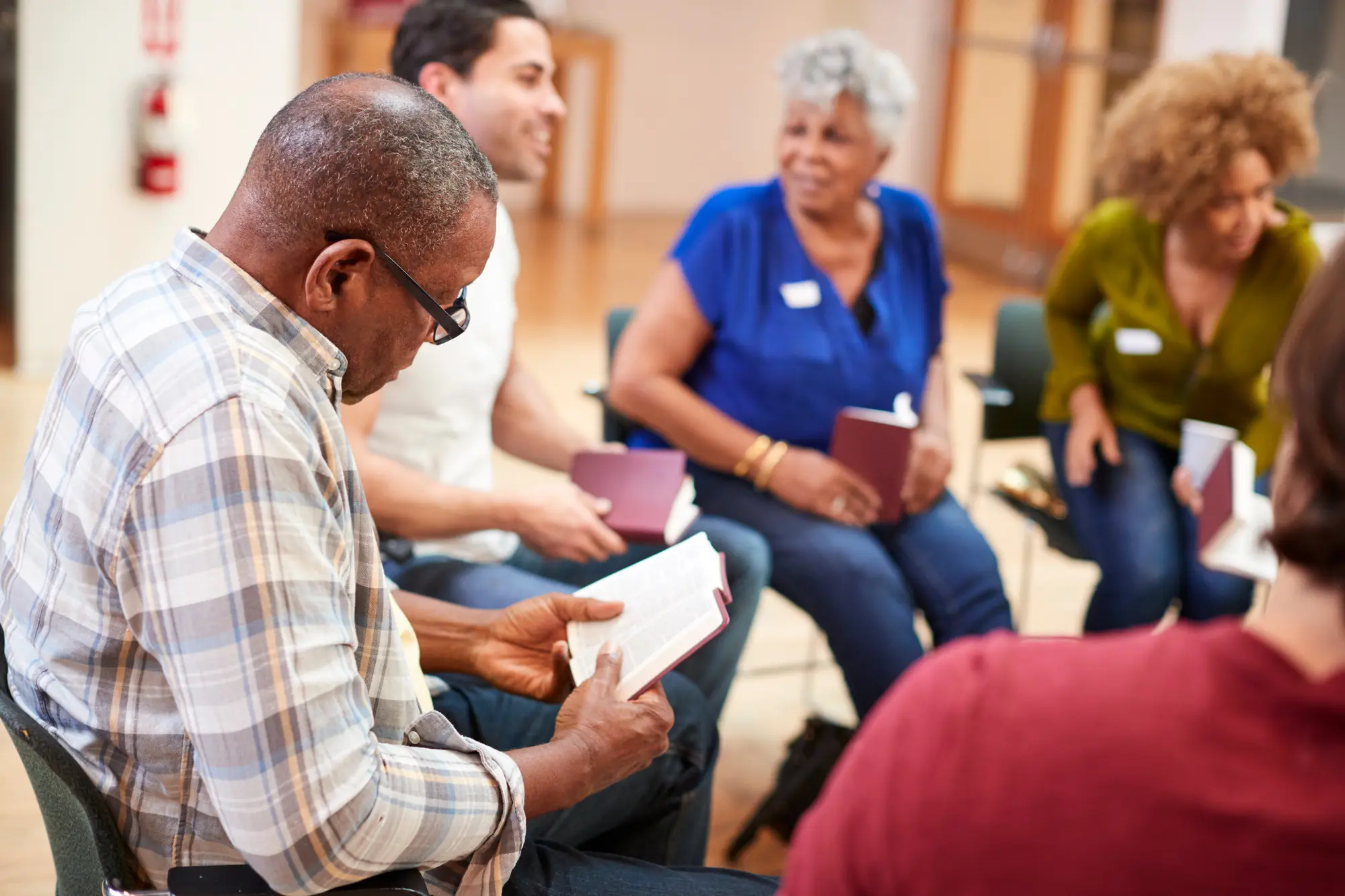 People Attending Bible Study Or Book Group Meeting In Community Center
