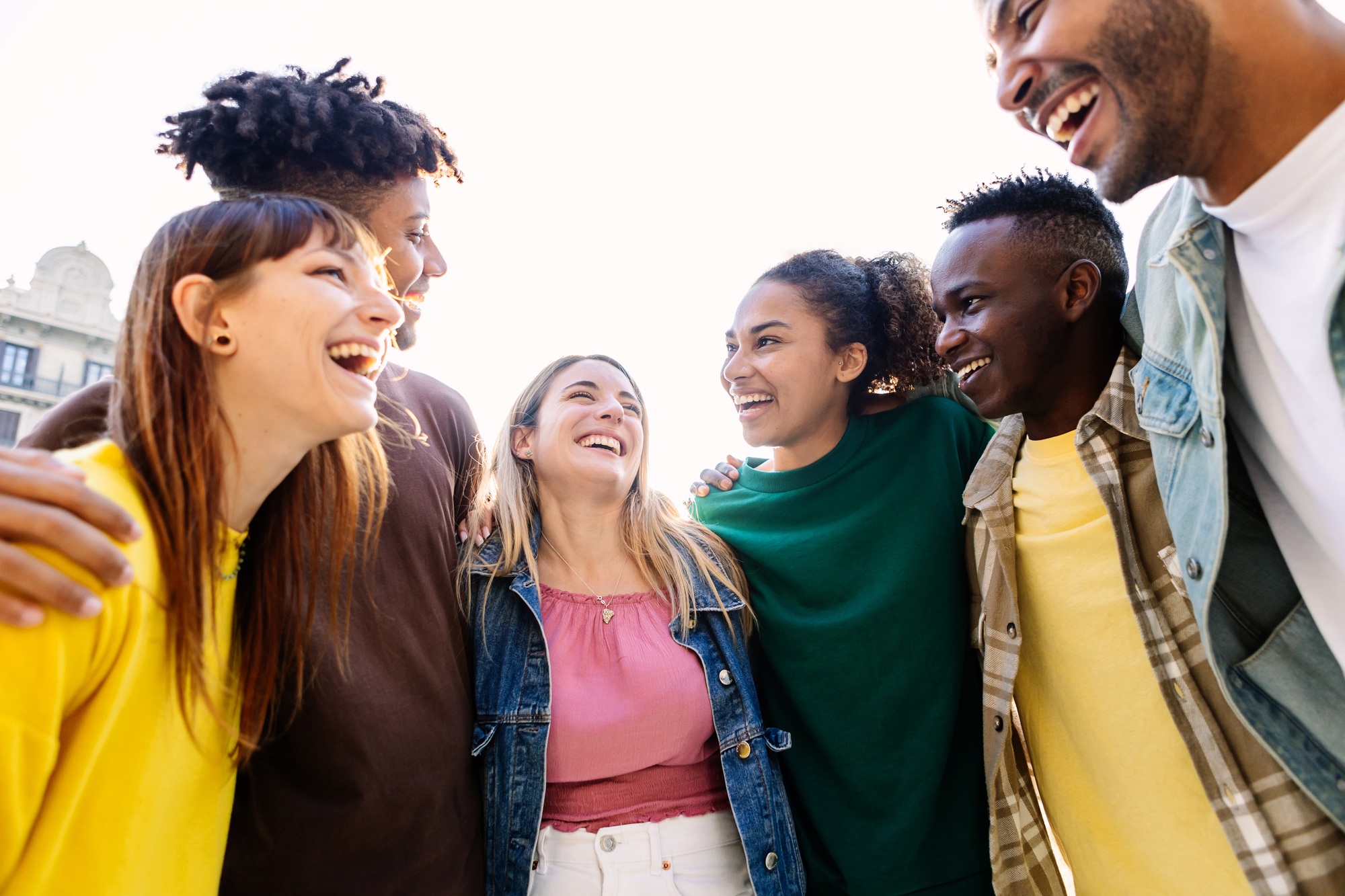 Youth group of college student friends hanging out together outside.